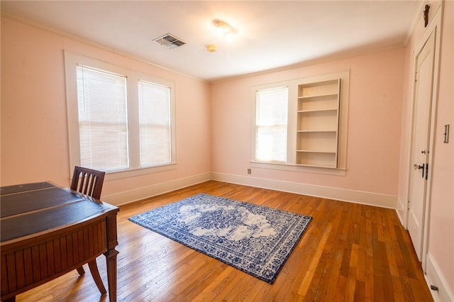 1107 N Adams St, Beeville, TX 78102 - office space featuring baseboards, plenty of natural light, crown molding, built in shelves, and hardwood / wood-style floors