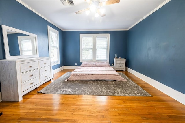 1107 N Adams St, Beeville, TX 78102 - bedroom with ornamental molding, wood finished floors, baseboards, and ceiling fan