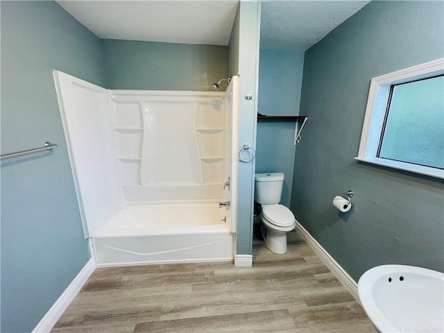 4313 Molina Dr, Corpus Christi, TX 78416 - full bath featuring wood finished floors, toilet, washtub / shower combination, and baseboards