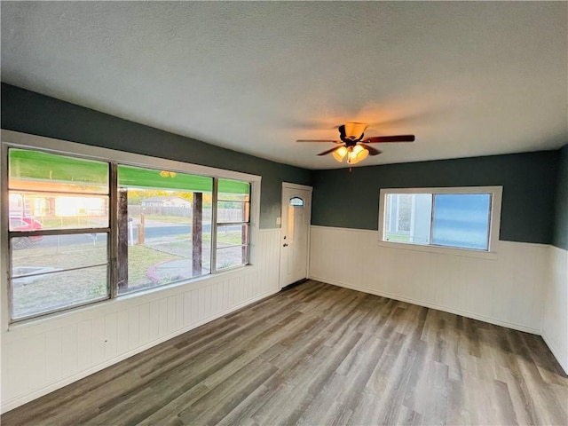 4313 Molina Dr, Corpus Christi, TX 78416 - empty room featuring wainscoting, wood finished floors, ceiling fan, and a textured ceiling