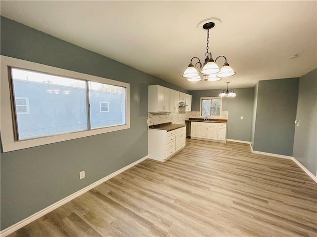 4313 Molina Dr, Corpus Christi, TX 78416 - kitchen featuring a chandelier, plenty of natural light, white cabinets, and baseboards