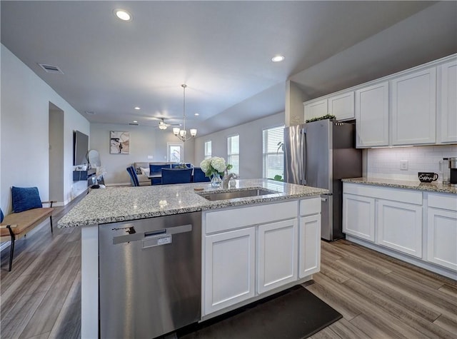 2693 Excelsior Blvd, Corpus Christi, TX 78415 - kitchen with appliances with stainless steel finishes, white cabinets, a kitchen island with sink, wood finished floors, and recessed lighting
