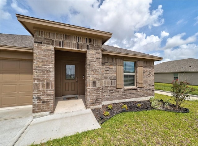 2693 Excelsior Blvd, Corpus Christi, TX 78415 - doorway to property featuring an attached garage, a lawn, and brick siding