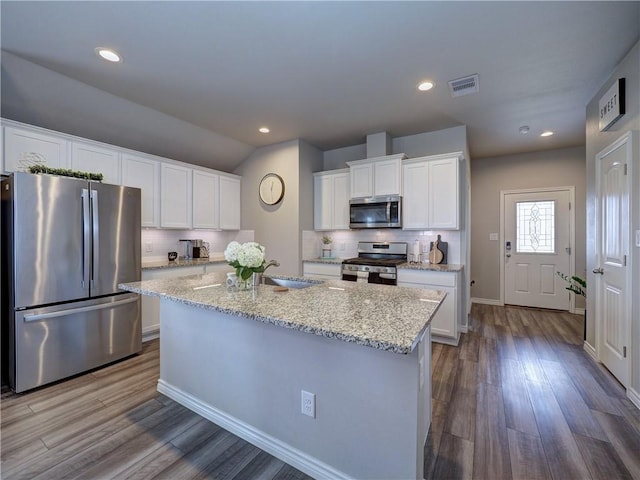 2693 Excelsior Blvd, Corpus Christi, TX 78415 - kitchen featuring appliances with stainless steel finishes, decorative backsplash, white cabinetry, wood finished floors, and recessed lighting