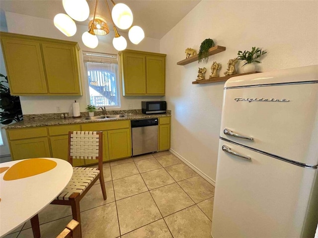 kitchen with a sink, stainless steel dishwasher, freestanding refrigerator, black microwave, and light tile patterned floors