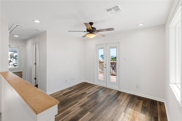 empty room with french doors, plenty of natural light, ceiling fan, and dark hardwood / wood-style flooring