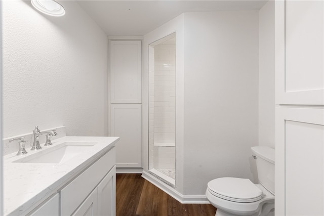 bathroom with toilet, a shower, vanity, and hardwood / wood-style flooring