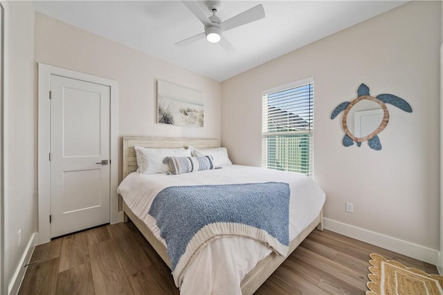 bedroom with baseboards, a ceiling fan, and wood finished floors