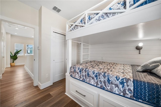 bedroom featuring dark wood-type flooring, a closet, visible vents, and baseboards
