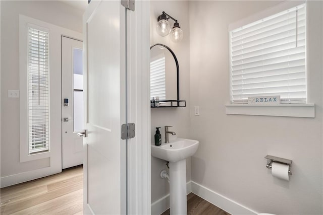 bathroom with wood finished floors, baseboards, and a sink