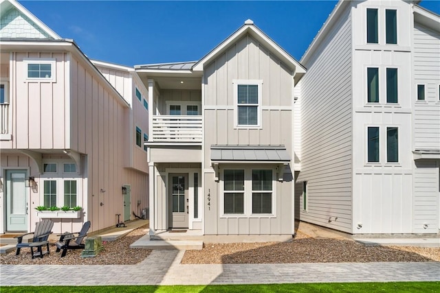 view of front of house with board and batten siding, a standing seam roof, and metal roof