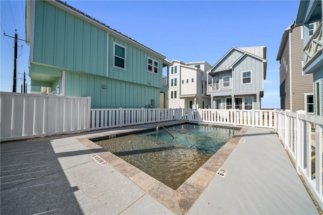 community pool featuring a residential view and fence