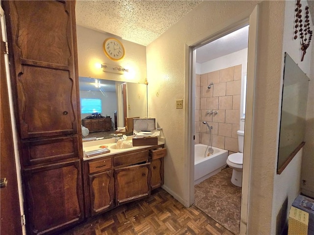 bathroom featuring toilet, shower / bathtub combination, a textured wall, a textured ceiling, and vanity