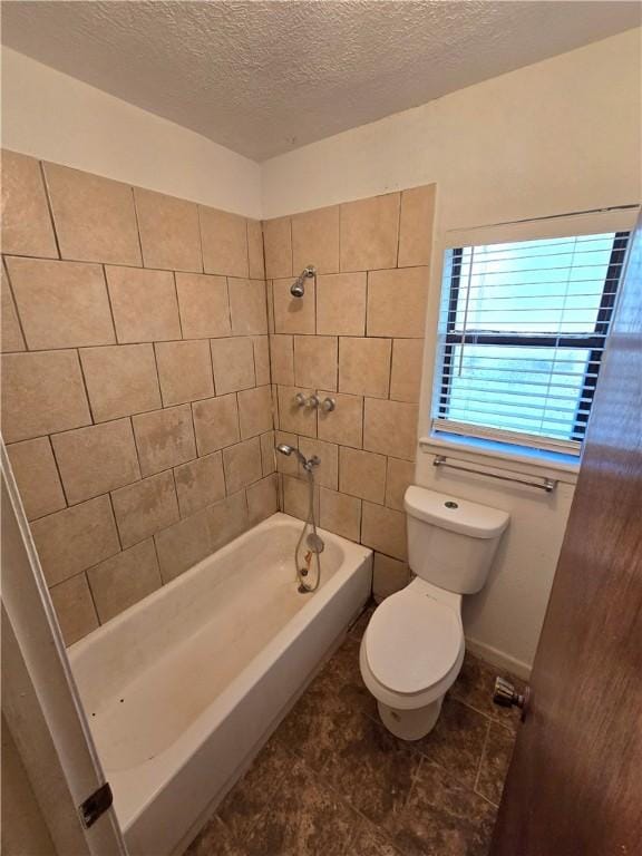 full bathroom with tile patterned flooring, toilet, washtub / shower combination, and a textured ceiling