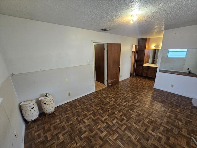 unfurnished room with visible vents and a textured ceiling