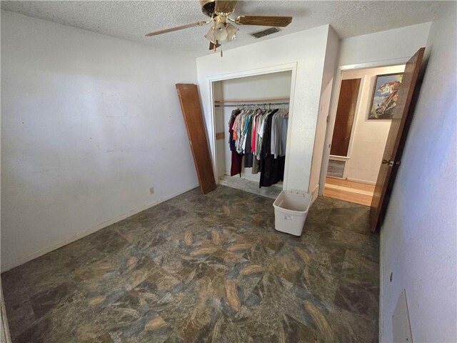 bedroom with a closet, visible vents, a textured ceiling, and ceiling fan