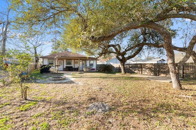 view of yard with a patio area, a fenced backyard, and a fire pit