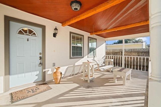 view of exterior entry with covered porch and stucco siding