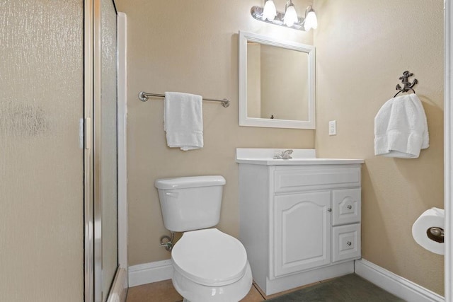 full bathroom featuring toilet, a shower stall, baseboards, and vanity