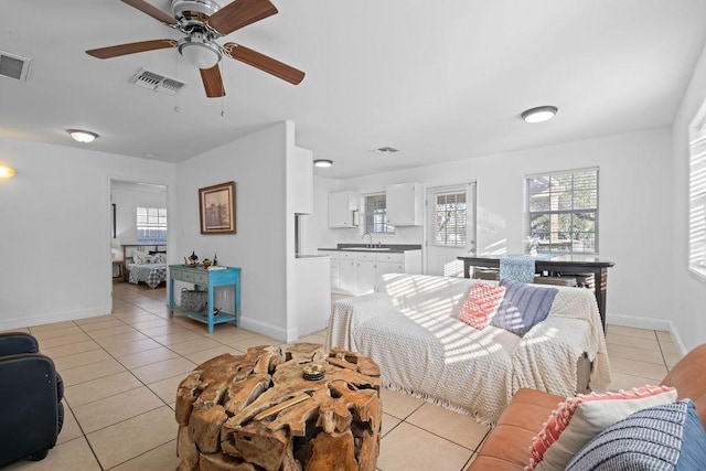 living room featuring light tile patterned floors, baseboards, visible vents, and ceiling fan