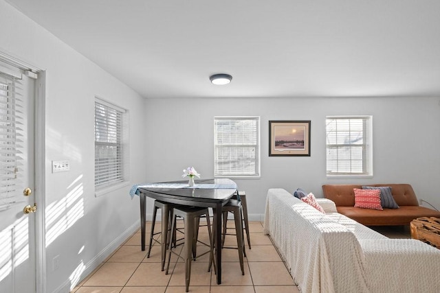 dining room featuring light tile patterned floors, plenty of natural light, and baseboards