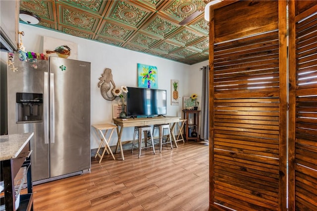 3938 Surfside Blvd Unit 2244, Corpus Christi, TX 78402 - kitchen featuring light stone counters, wood finished floors, stainless steel refrigerator with ice dispenser, and an ornate ceiling