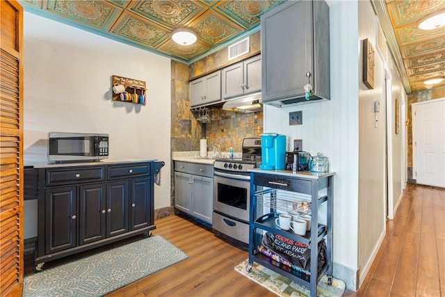 3938 Surfside Blvd Unit 2244, Corpus Christi, TX 78402 - kitchen with appliances with stainless steel finishes, decorative backsplash, wood finished floors, and an ornate ceiling