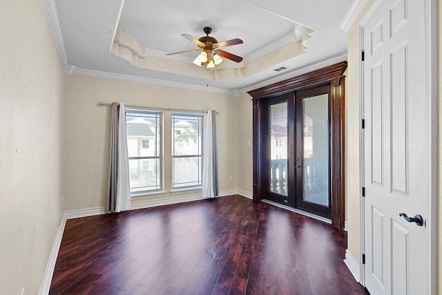 empty room with french doors, ornamental molding, a raised ceiling, ceiling fan, and dark wood-type flooring