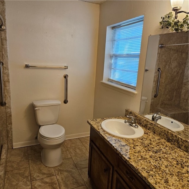 bathroom with toilet, vanity, tile patterned flooring, and tiled shower