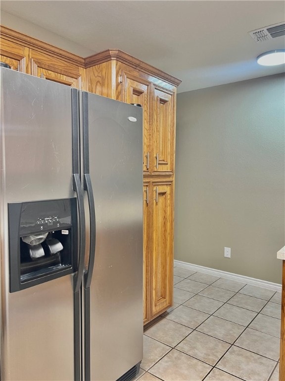 kitchen featuring stainless steel refrigerator with ice dispenser and light tile patterned floors