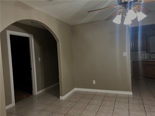 tiled spare room with sink and ceiling fan