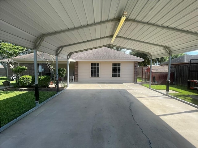 view of vehicle parking featuring a lawn and a carport