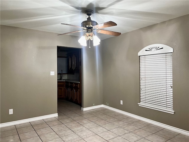 tiled spare room with sink and ceiling fan