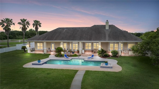 1618 Cantera Bay, Corpus Christi, TX 78418 - back of house at dusk with a patio area, a chimney, a shingled roof, and stucco siding