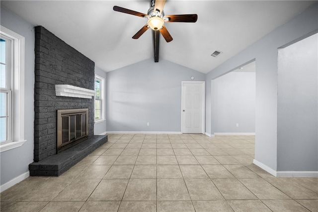 unfurnished living room featuring ceiling fan, lofted ceiling with beams, light tile patterned flooring, and a brick fireplace