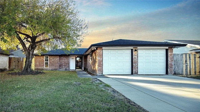 single story home featuring a yard and a garage