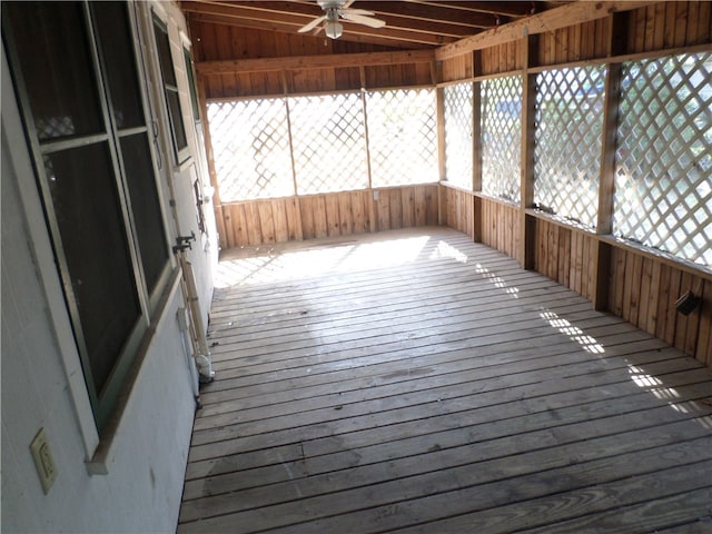 unfurnished sunroom featuring ceiling fan