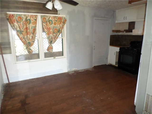 interior space featuring a textured ceiling, dark wood-type flooring, and ceiling fan