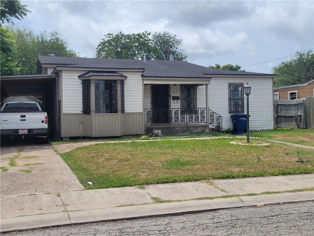 1438 Melbourne Dr, Corpus Christi, TX 78415 - view of front facade with a porch, a front yard, driveway, and an attached carport