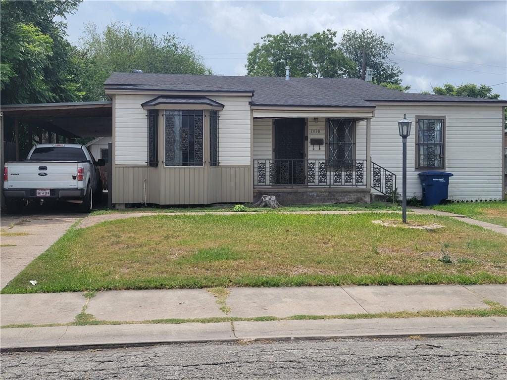 1438 Melbourne Dr, Corpus Christi, TX 78415 - view of front of property with covered porch, a front yard, concrete driveway, and an attached carport