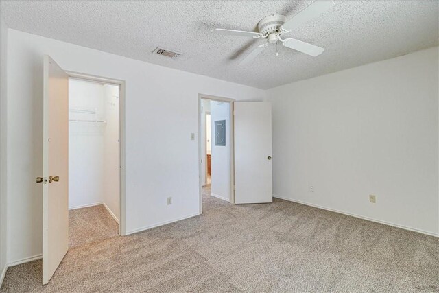 6702 Everhart Unit N102, Corpus Christi, TX 78413 - unfurnished bedroom featuring carpet floors, a spacious closet, a textured ceiling, a closet, and electric panel