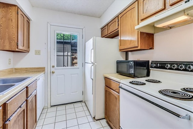 6702 Everhart Unit N102, Corpus Christi, TX 78413 - kitchen with white appliances, under cabinet range hood, light countertops, light tile patterned flooring, and brown cabinetry