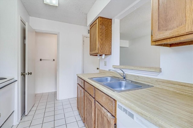 6702 Everhart Unit N102, Corpus Christi, TX 78413 - kitchen with white stove, a textured ceiling, light countertops, light tile patterned flooring, and brown cabinetry