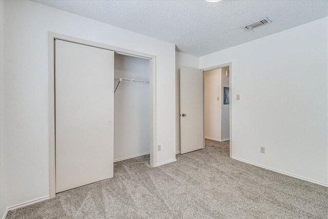 6702 Everhart Unit N102, Corpus Christi, TX 78413 - unfurnished bedroom featuring carpet flooring, a textured ceiling, and a closet