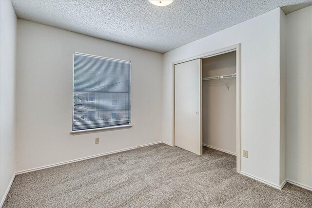 6702 Everhart Unit N102, Corpus Christi, TX 78413 - unfurnished bedroom with carpet floors, a closet, and a textured ceiling