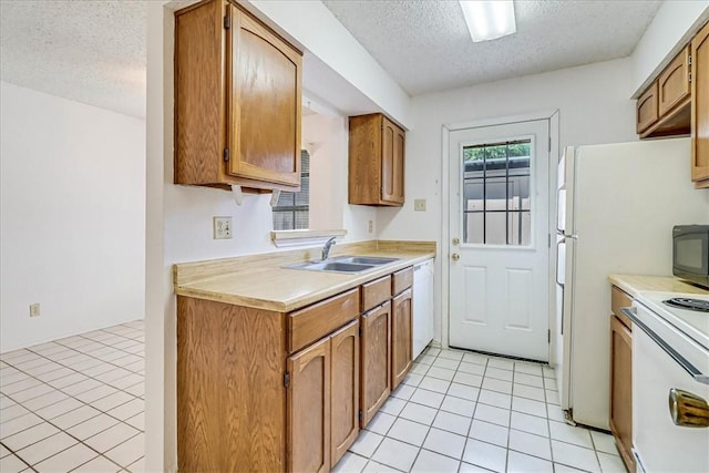 6702 Everhart Unit N102, Corpus Christi, TX 78413 - kitchen featuring a textured ceiling, white appliances, light tile patterned flooring, light countertops, and brown cabinetry