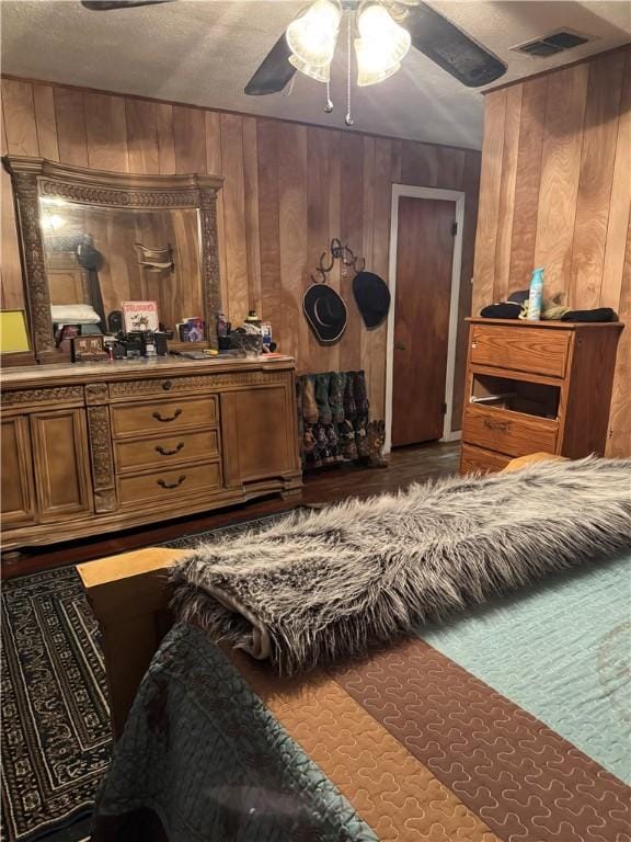 208 W Plasuela St, Refugio, TX 78377 - bedroom with ceiling fan, wooden walls, and a textured ceiling
