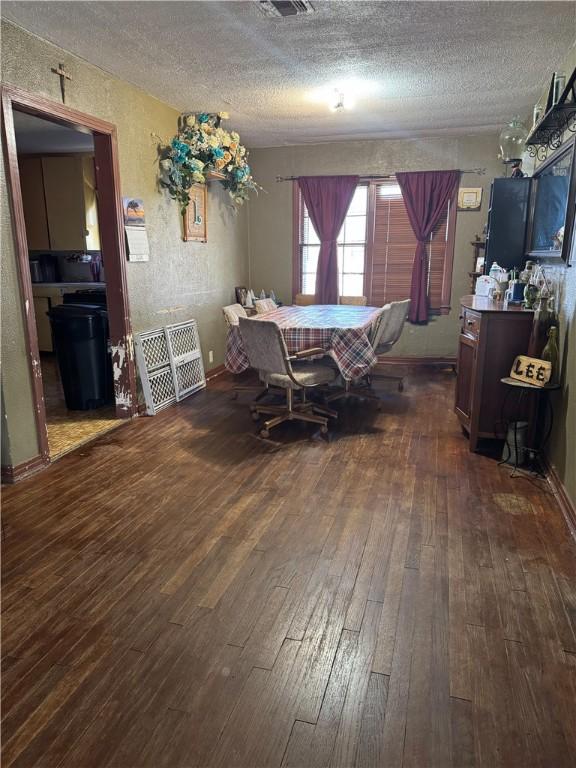 208 W Plasuela St, Refugio, TX 78377 - dining area with dark hardwood / wood-style flooring and a textured ceiling