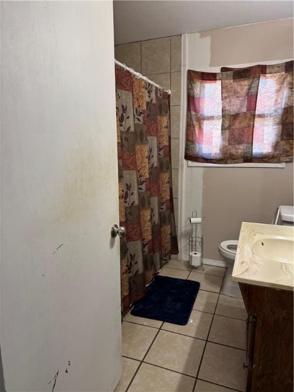208 W Plasuela St, Refugio, TX 78377 - bathroom featuring a shower with curtain, vanity, tile patterned floors, and toilet