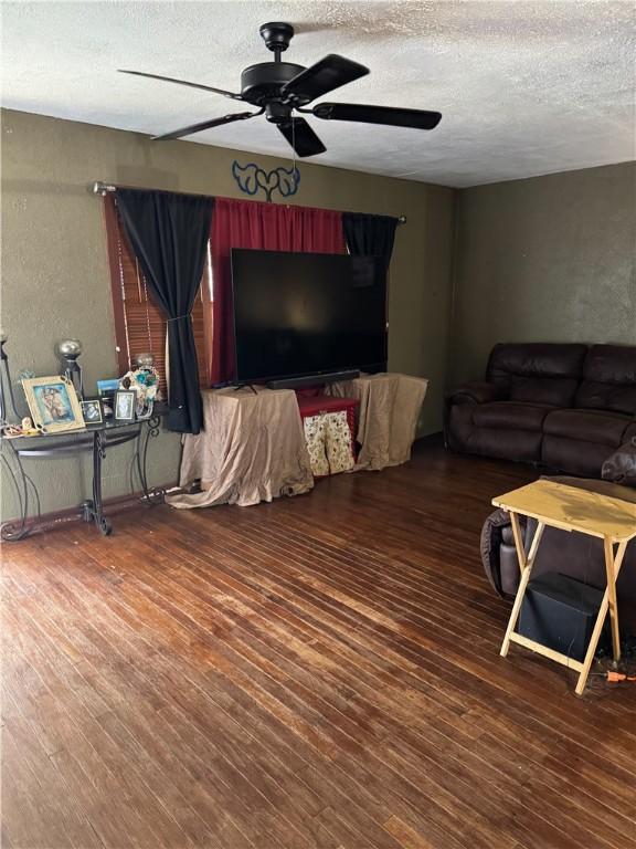208 W Plasuela St, Refugio, TX 78377 - living room featuring ceiling fan, dark hardwood / wood-style flooring, and a textured ceiling